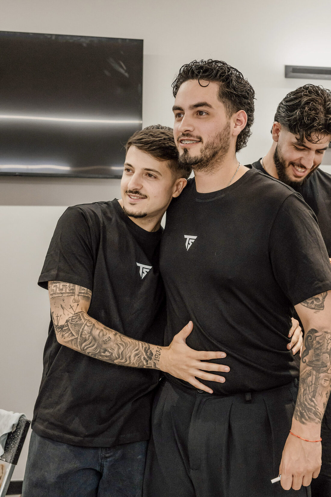 Dois membros da equipa abraçados dentro do salão